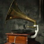 Antique gramophone with wooden base and brass horn.